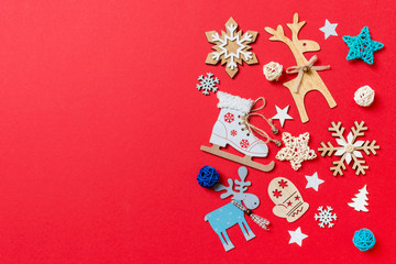 Top view of holiday toys and decorations on red Christmas background. New Year time concept with copy space