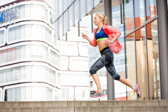 European Quarter, Stuttgart, Baden-W&cedil;rttemberg, Germany: A female runner running through the city during her morning run.