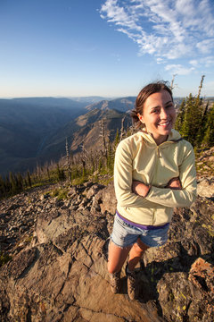 A woman enjoys the view of Hells Canyon at sunset from the Dry Diggins Lookout in the Seven Devil Mountains in central Idaho.  With a 6500+ foot slope to the Snake River at the bottom of the canyon, it is the deepest canyon in North America.