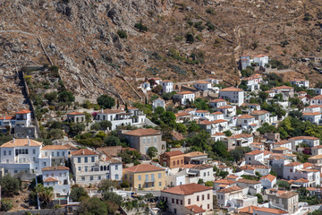 Fototapeta na wymiar Houses and buildings in the mountains with trees and vegetation in Hydra Island