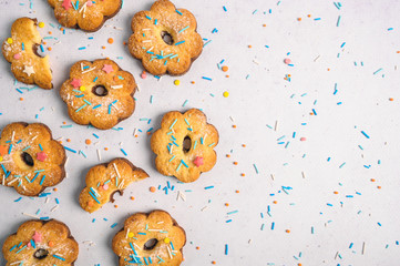 Delicious cookies on white background dusted with multicolored sprinkling.