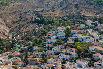 Naklejka premium Houses and buildings in the mountains with trees and vegetation in Hydra Island