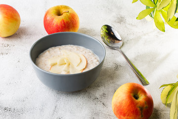 Oatmeal porridge or porridge oats or breakfast cereals with apple isolated on white marble background. Homemade food. Tasty breakfast. Selective focus. Hotizontal photo.