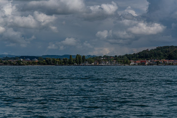 Fototapeta na wymiar The shoreline at lake constance with clouds in the background