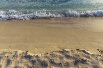 Big wave in Caribbean sea is breaking the coast. Turquoise sea water and blue sky. Eagle Beach of Aruba Island.  Beautiful nature background.