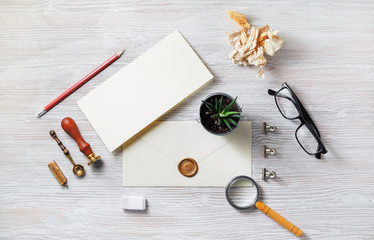 Blank vintage envelope and retro stationery set on light wooden background. Template for placing your design. Flat lay.