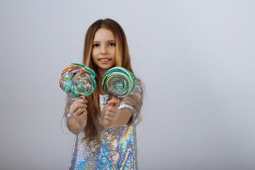 beautiful girl smiles and holds a lolly in her hands. a marshmallow long blond hair.