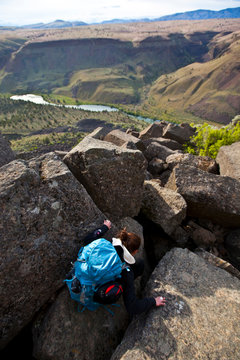 A female climber descends the toppled columns at Trout Creek, a climbing area in central Oregon.