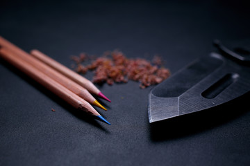 pencil and knife on black background