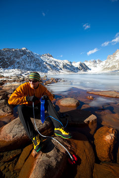 A man pumps some water using an MSR filter at one of the many beautiful Titcomb Lakes in the Titcomb Basin deep in the Wind River Range in Wyoming.