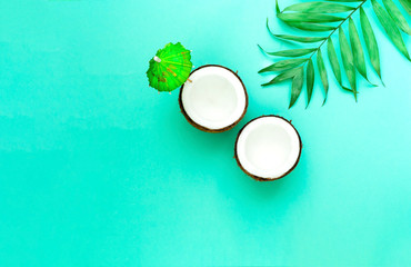 Obraz na płótnie Canvas Creative layout of coconuts mit decorative umbrella on green background.Trendy color 2020. Copy space