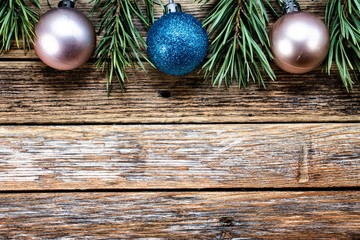 Christmas balls and pine branches on wooden background. Winter holiday concept. View from above. Copy space