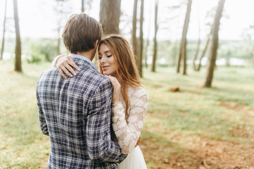 Fototapeta premium A young couple of brides walking in the pine forest