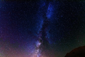 starry night with the Milky Way on the Turkish Mediterranean coast amidst the rocky mountains with tourists in a yellow tent