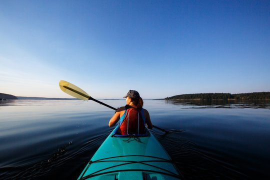 Rear view of woman kayaking in sea