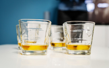 Close up on three glasses whiskey or brandy or cognac alcohol drink on the white table at home