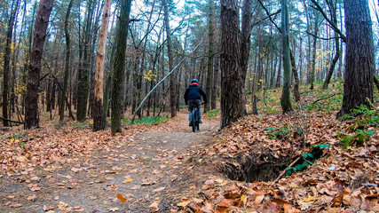 Amateur rider on the bicycle in the autumn park