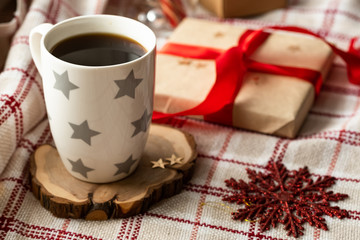 Christmas cup of hot coffee with christmas decoration on a plaid. Festive backdrop for holidays. Christmas composition. Image for display your christmas products.
