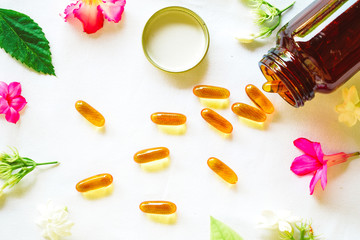 Fish oil capsules decorated with colorful flowers for healthy lifestyle concept
