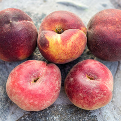 Group of fresh peaches lying on a stone table