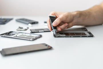 Man repair modern smartphone in service center