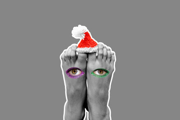 Fototapeta premium Feet and eyes with a hat of Santa Claus. Modern art collage. Concept art. New Year's and Christmas. Creative style