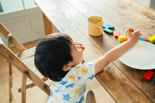 テーブルに手を伸ばす男の子