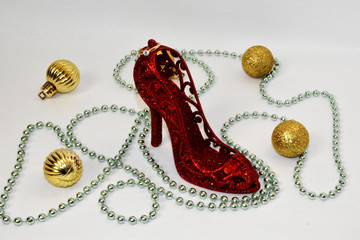 A red shoe is located on a white background, and on it lies a golden ring with a pebble. Original marriage proposal. Greeting card of declaration of love.