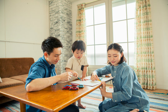 リビングで遊ぶ家族三人