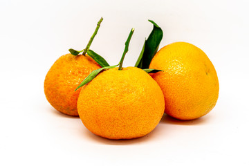 Clementines with leaves isolated against a white background