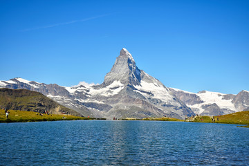 Majestic Matterhorn viewed from Stellisee Lake with a Gorgeous Cloudless Sky (with small airplane in the distance)