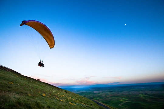 Darrell Anglen lifts off into the twilight while paragliding off Steptoe Butte in the Palouse at dusk.