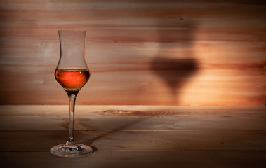 Glass of strong alcohol on a wooden background