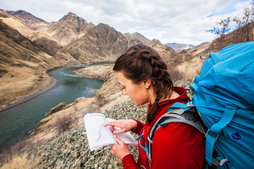 A woman points at a location shown on a map at Hells Canyon in Idaho while on a weekend backpacking trip[ from Pittsburg Landing to Kirkwood Ranch the Snake River National Recreation Trail #102.