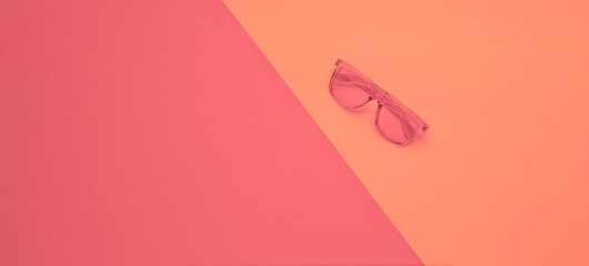 Minimal fashion, Trendy sunglasses. Party vibration on pink geometry background. Hipster accessory Flat lay. Art creative summer vibes fashionable style. Design vibrant color, gel filter. Banner