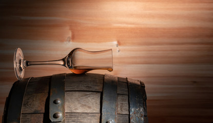 A glass of whiskey is on the barrel