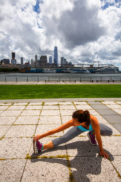 A Woman Stretches On Hudson River Park Pier 45 Near Downtown Manhattan In New York City.