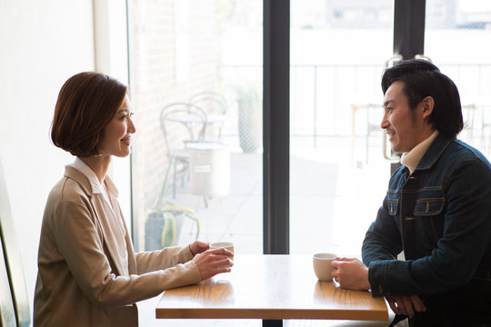 カフェで話す笑顔の男女