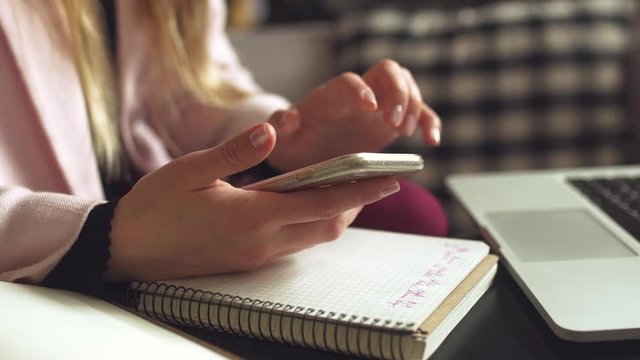 woman sitting coffee shop wooden table, drinking coffee and using smartphone. Woman Using Phone In Cafe. Student learning online. Girl checking email. Woman Cafe, use mobile Phone, Working Notebook