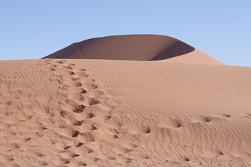 Sanddüne mit Fussspuren im Vordergrund