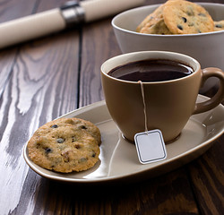 cup of coffee and chocolate chip cookies on table