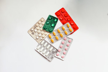 Heap of medical pills in white, green, red  and other colors. Pills in plastic package. Concept of healthcare and medicine.