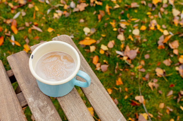 Metal blue cup with coffee on a table