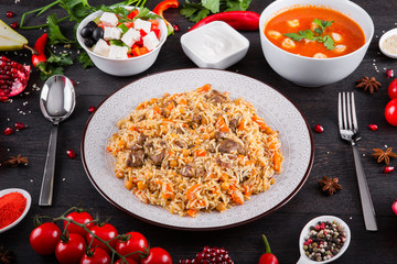 The concept of Eastern asian festive cuisine. Assorted Uzbek food set, pilaf, samsa, lagman, manta, shurpa restaurant concept, Uzbek food. Homemade Eastern arabic new year and Christmas dish from lamb