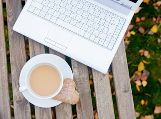 cup of coffee and cookies with laptop computer
