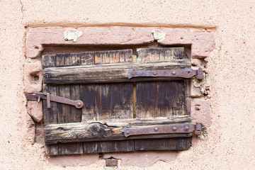 Small antique wooden door with an iron rusty latch, closeup
