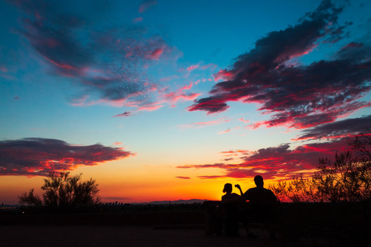 Colorful sky after the sun went down, couple enjoying the scenic nature, taking pictures