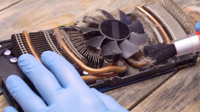The wizard removes dust on the processor, fan of the computer or video card with a brush and vacuum cleaner.