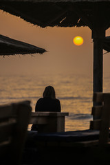 Girl watching sunrise on sea resort
