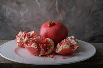 The fruit is a pomegranate on a large white plate.